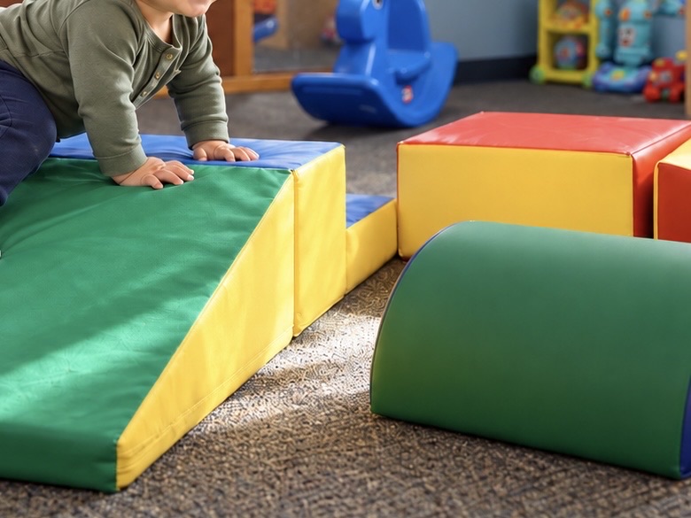 Young toddler climbing soft play blocks at Sunny Pointe Childcare Center in Northville