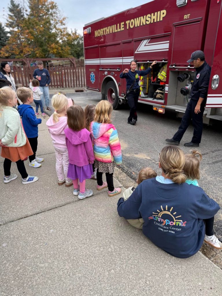 Northville Township firefighters showing Sunny Pointe children their fire truck